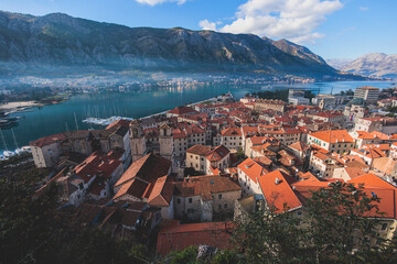 Naklejka na ściany i meble Kotor, Montenegro, beautiful top panoramic view of Kotor city old medieval town seen from San Giovanni St. John Fortress, with Adriatic sea, bay of Kotor and Dinaric Alps mountains in a sunny day