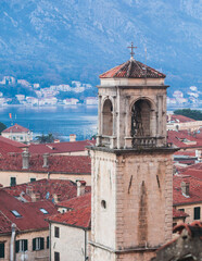 Fototapeta premium Kotor, Montenegro, beautiful top panoramic view of Kotor city old medieval town seen from San Giovanni St. John Fortress, with Adriatic sea, bay of Kotor and Dinaric Alps mountains in a sunny day