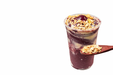Acai bowl with banana and a spoonful of granola on white background.
