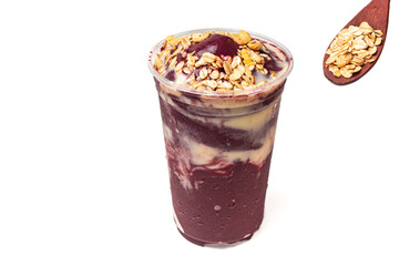 Acai bowl with banana and a spoonful of granola on white background.