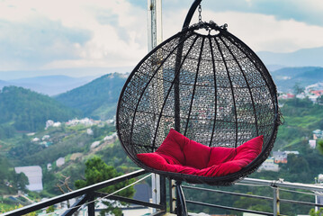 Hanging chair with pillow against mountains in Da Lat city in Vietnam