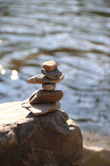Balancepyramide aus Steinen steht auf Felsen am Fluss