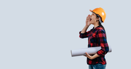 Young female engineer wearing a yellow safety helmet with Blueprints
