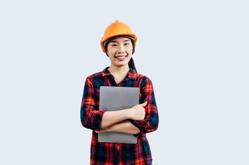 Young female engineer wearing Yellow helmet and use laptop computer