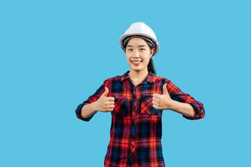 Young female engineer in helmet stand with thumb up posture