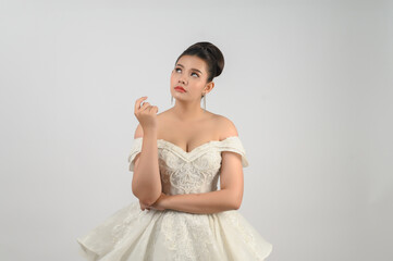 Portrait of beautiful Asian bride in luxurious wedding dress in thoughtful pose
