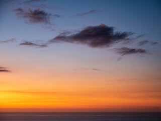 Sunset clouds over Tasma sea at Piha Beach, Auckland