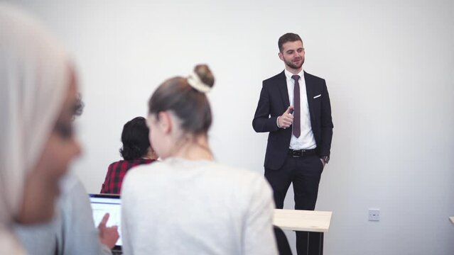 Teacher teaching multicultural studen in classroom at university