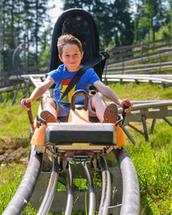 Gas geben auf der Sommerrodelbahn - Junge hat Spaß auf dem Alpine Coaster