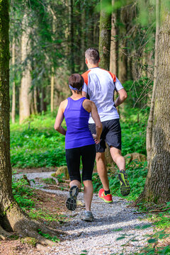 Junges Paar beim gemeinsamen Joggen im Wald