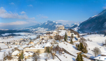 Aerial image of the medieval town Gruyeres with Castle on the hill top of Alps in winter. It is one...