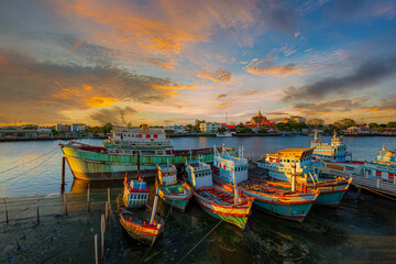 Fototapeta na wymiar evening view of fishing boat marina in thailand,Group of fishing boats docked at the Port of river in fisherman village in Pak nam,Rayong,Thailand.