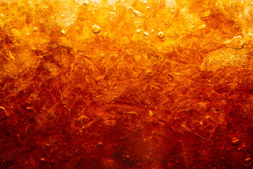 macro cola drink texture,macro soft drink texture,Close up view of ice cubes in dark cola background. Textures of sweet summer cold drinks with foam and macro bubbles on Fizzing glass wall. - obrazy, fototapety, plakaty