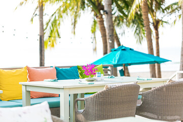 beach restaurant table,Luxury resort hotel poolside, outdoor restaurant on the beach, ocean and sky, tropical island cafe, tables, food. Summer vacation or holiday, family travel. Palm trees, infinity