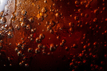 macro cola drink texture,macro soft drink texture,Close up view of ice cubes in dark cola background. Textures of sweet summer cold drinks with foam and macro bubbles on Fizzing glass wall. - obrazy, fototapety, plakaty