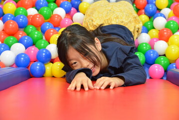 Fototapeta na wymiar カラーボールの中で遊ぶ子供