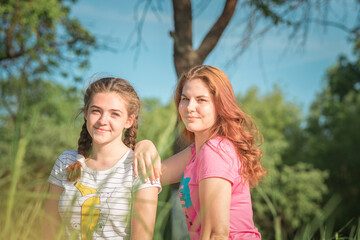 Portrait of young beautiful girlfriends in a summer park.