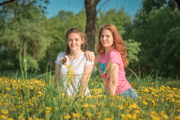 Portrait of young beautiful girlfriends in a summer park.
