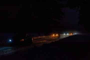 A line of cars, just after sunset, leaving a snow-covered Yosemite national park.