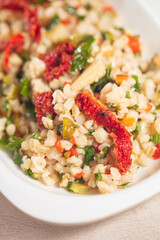 Tabbouleh salad - traditional Middle Eastern or Arabic cuisine. Levantine vegetarian salad with bulgur, quinoa, tomato, cucumber, parsley and lemon juice. Tabbouleh with bulgur closeup. High quality