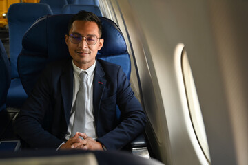 Image of pleased businessman in elegant suite sleeping in plane during business travel