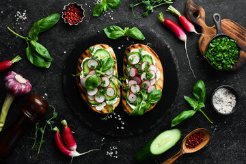 Vegan Sandwich with radish, cucumber, cheese and basil. Bruschetta. Top view. On a stone background.