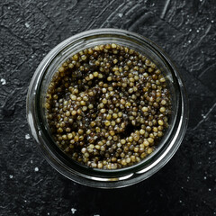 A jar with high-quality black caviar. Luxury food. On a concrete background.