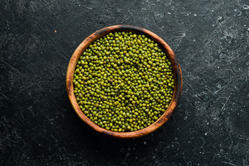 Organic green mung bean in a bowl on a stone background. Top view.