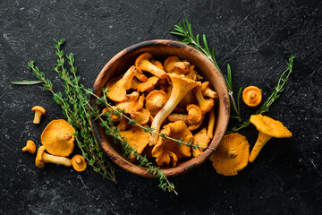 Chanterelle mushrooms in a bowl. Organic forest food. Top view. On a stone background.