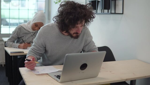 Student using formula math sheet to cheat on test. Hand of university student holding pencil doing math question in examination and cheating with answer piece of paper in hand. Education concept