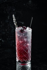 A cooling drink. Blackberry lemonade with tonic, ice and lavender in a glass. Cocktails. Bar menu.