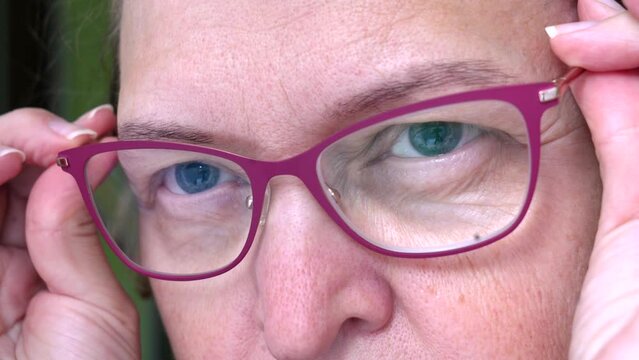 Middle-aged woman wearing glasses with pupils dilated of eyes, face woman in glasses, closeup