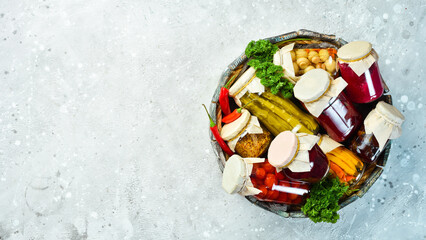 Wooden box with food supplies. Marinated vegetables. Food stocks in case of crisis. On a stone background. Top view.