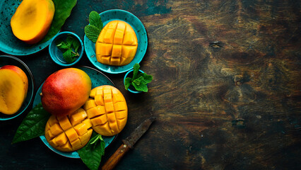 Mango background. Fresh delicious sweet mangoes in a plate. Top view. Copy space.
