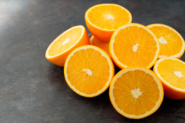 Orange slices on a black background. Halves of juicy oranges for a healthy diet