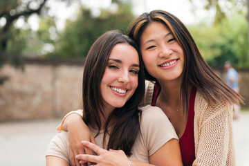 portrait of a young female couple smiling and looking at camera, concept of friendship and teenager lifestyle, copy space for text