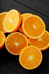 Bright halves of oranges on a wooden table. Halves of juicy oranges on black boards