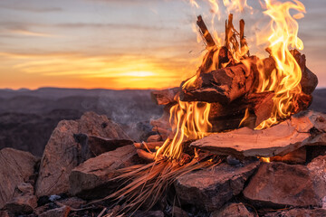 Burning wood at dawn. Atlas Mountains on the background