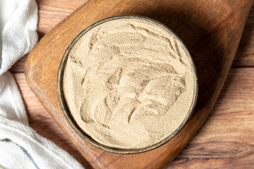 Powdered white pepper spice. Ground powdered white peppercorns in a bowl on a wooden background. Dry spice concept. Top view