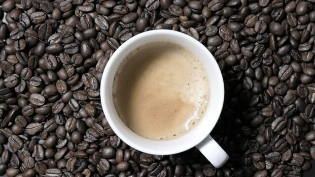 回転するコーヒーカップとコーヒー豆