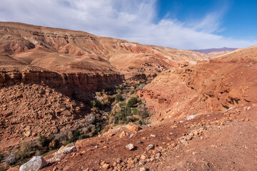 View of a village with steep dirt path into the dry arid valley