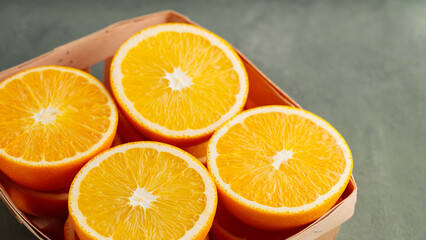 Halves of oranges in a wooden box. Fresh juicy oranges close up