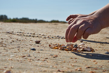 Girl lays out a drawing in the sand.
