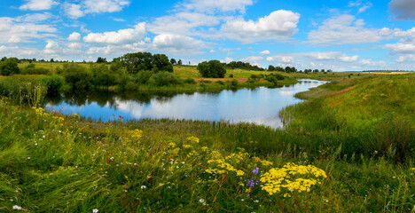 Beautiful summer or spring panoramic rural landscape with calm river and green hills with blooming wild flowers and trees at sunny summer day.River Upa in Tula region,Russia. - obrazy, fototapety, plakaty