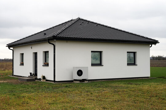 Heat pump outdoor unit in modern new house of future using green electric energy, efficient heat pump save money