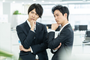 真剣に考えるスーツを着た日本人男性