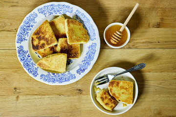 harcha or mbasses semolina algerian pancakes on an arabesque colorful plate. Traditional algerian breakfast bread with honey bowl