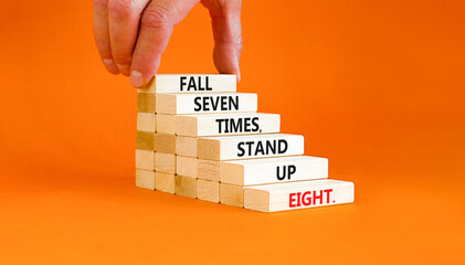 Stand up symbol. Concept words Fall seven times stand up eight on wooden blocks. Beautiful orange table orange background. Businessman hand. Business stand up concept. Copy space.