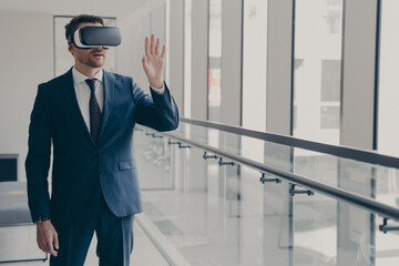 Excited office worker dressed in formal clothes managing business project through virtual reality