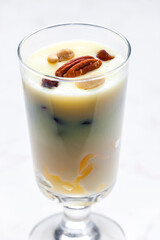 vanilla custard with nuts and raisins in a glass